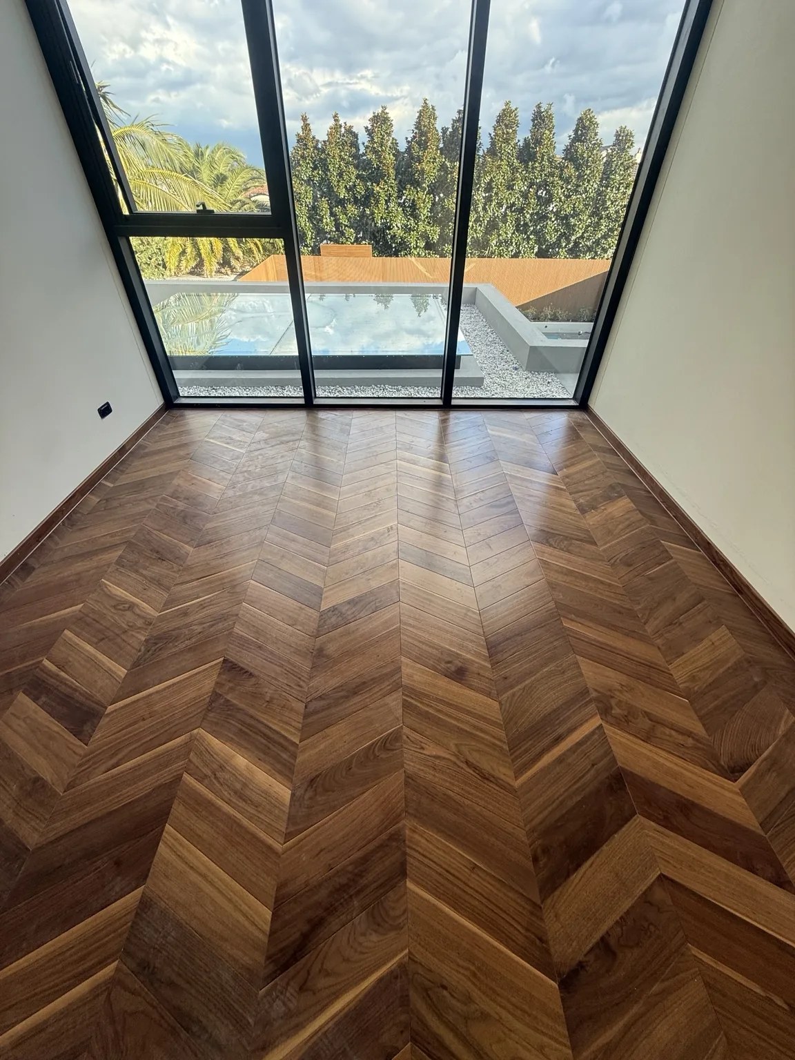 Premium dark timber chevron flooring by window