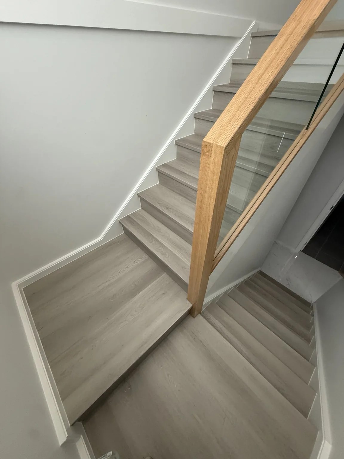 Grey timber staircase with glass balustrade